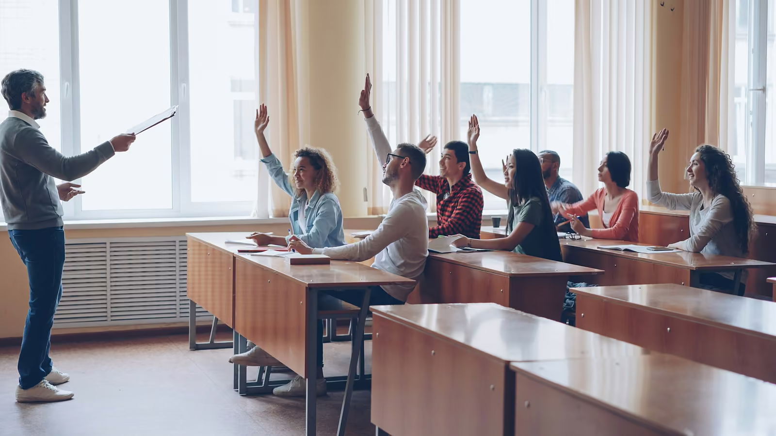 A teacher taking answers from students with their hands raised